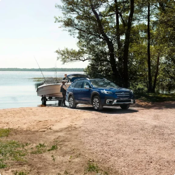 Subaru Outback från bilfirma Ronneby sjösätter båt vid strandkant.