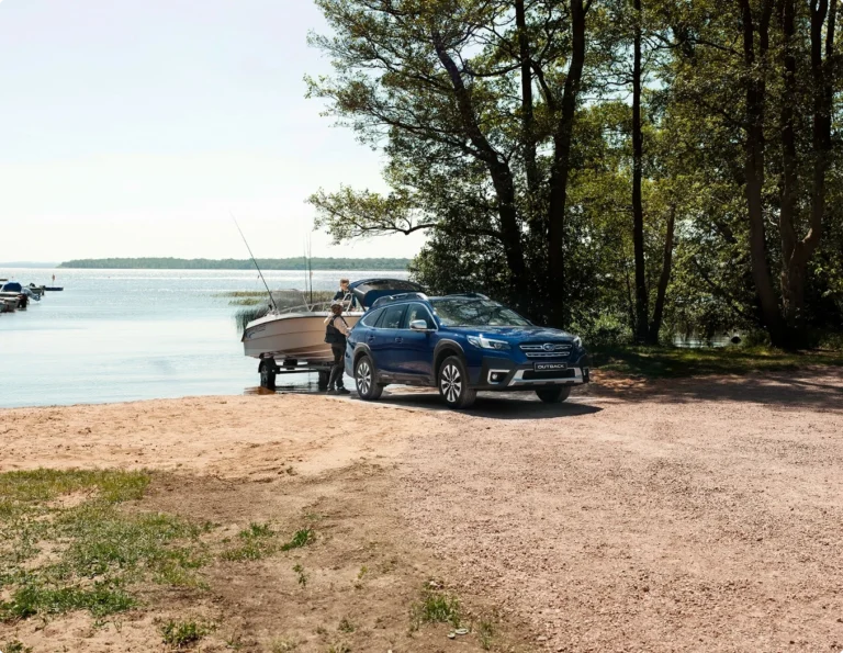 Subaru Outback från bilfirma Ronneby sjösätter båt vid strandkant.
